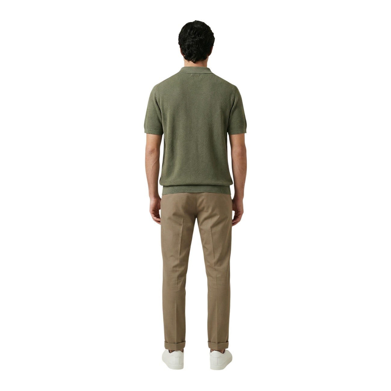 Back view of a man wearing a green polo shirt with short sleeves and collar on a white background.