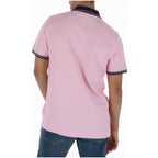 Back view of the pink polo shirt featuring short sleeves.