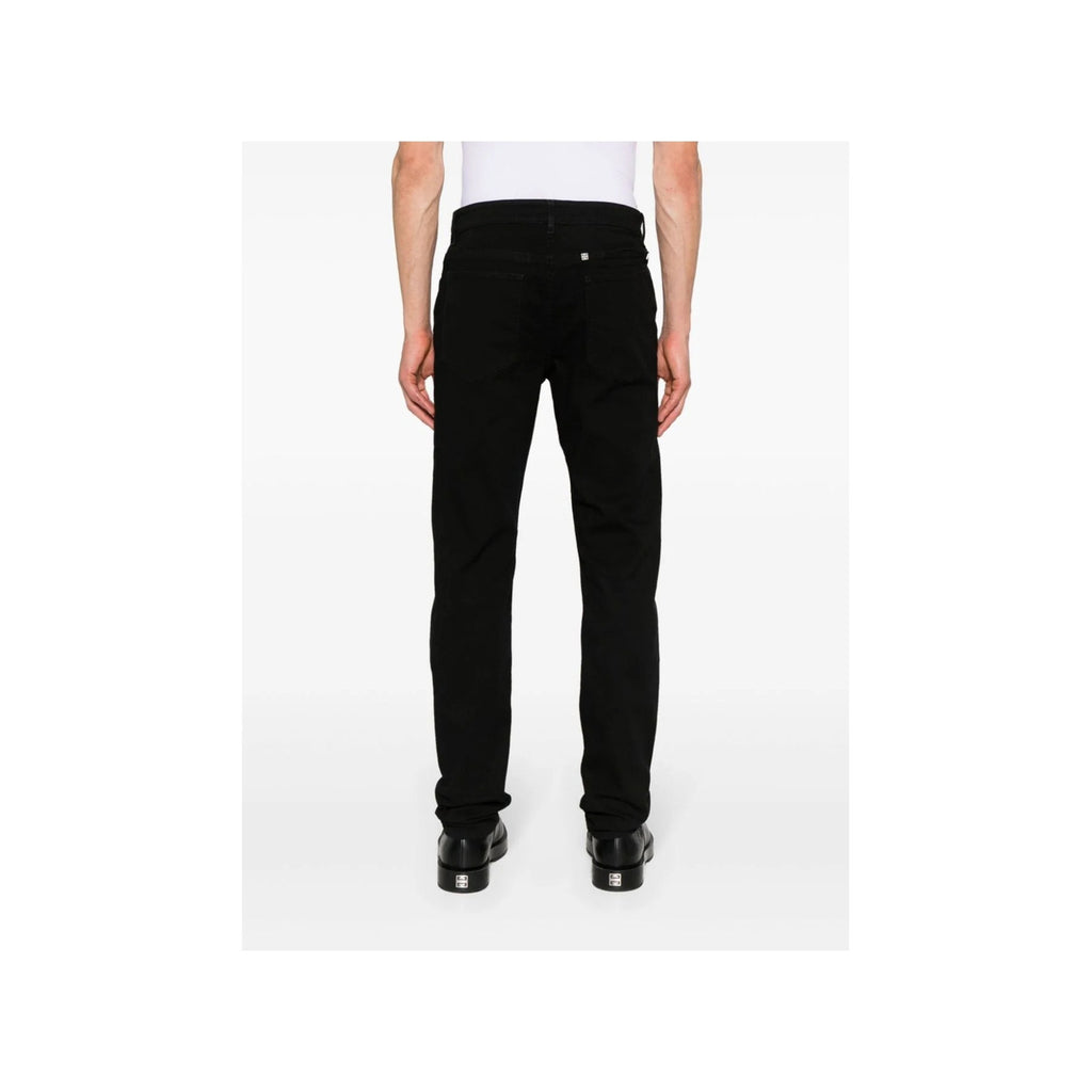 Back view of black Givenchy men's jeans with flared legs and pockets on a white background.