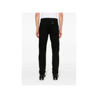 Back view of black Givenchy men's jeans with flared legs and pockets on a white background.