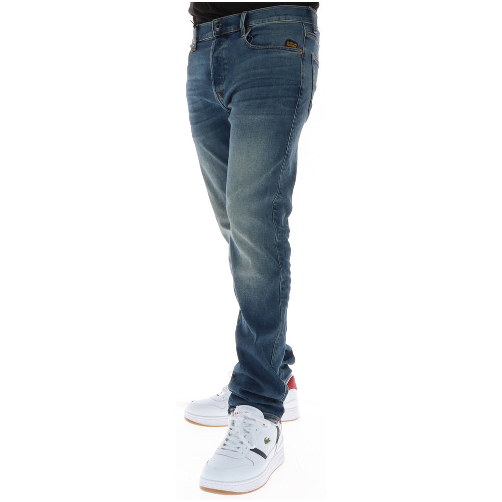 Side view of blue jeans with a faded wash and slim fit on a white background