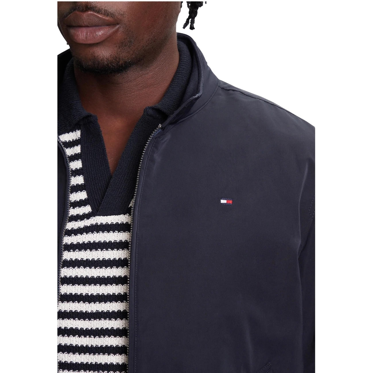 Detail close-up of the navy blazer collar with a striped shirt and logo on a white background