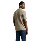 Back view of the beige polo shirt showcasing short sleeves and a collar on a white background.