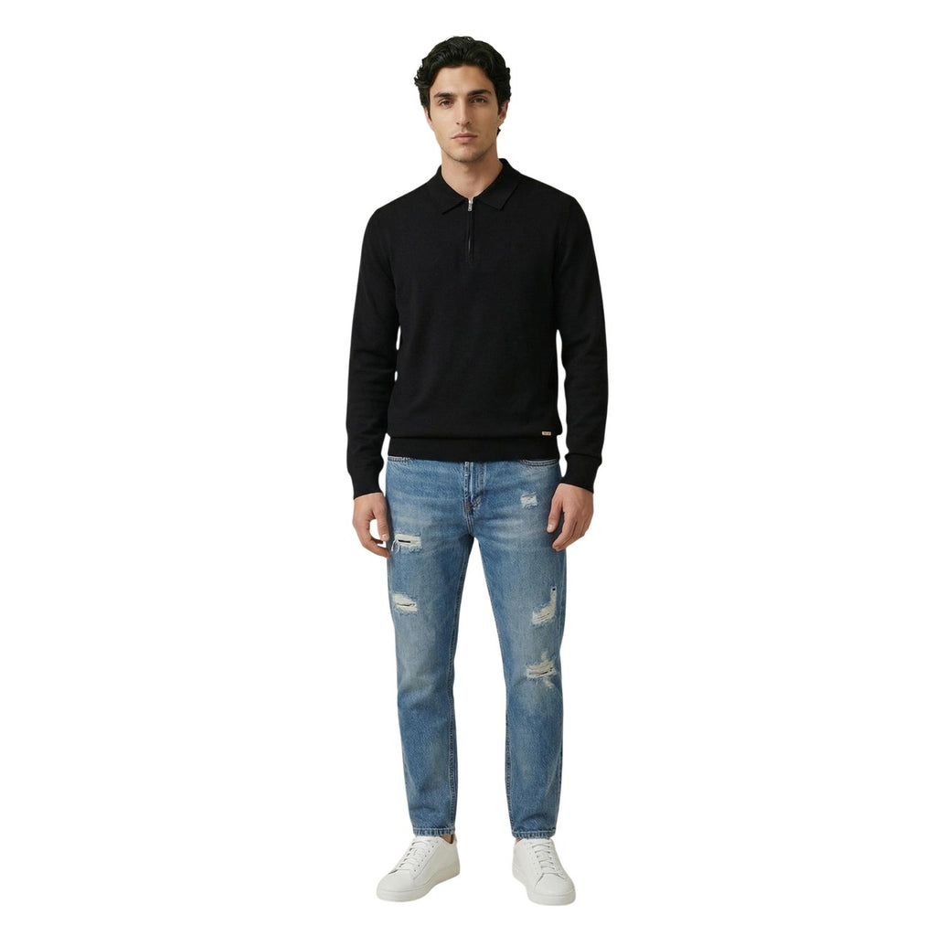 Front view of the black sweater paired with distressed jeans on a white background