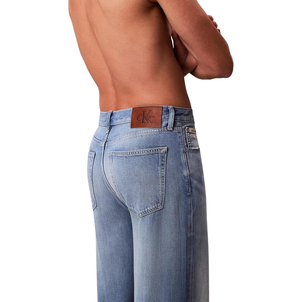 Side view of blue wide leg jeans with light wash on a white background
